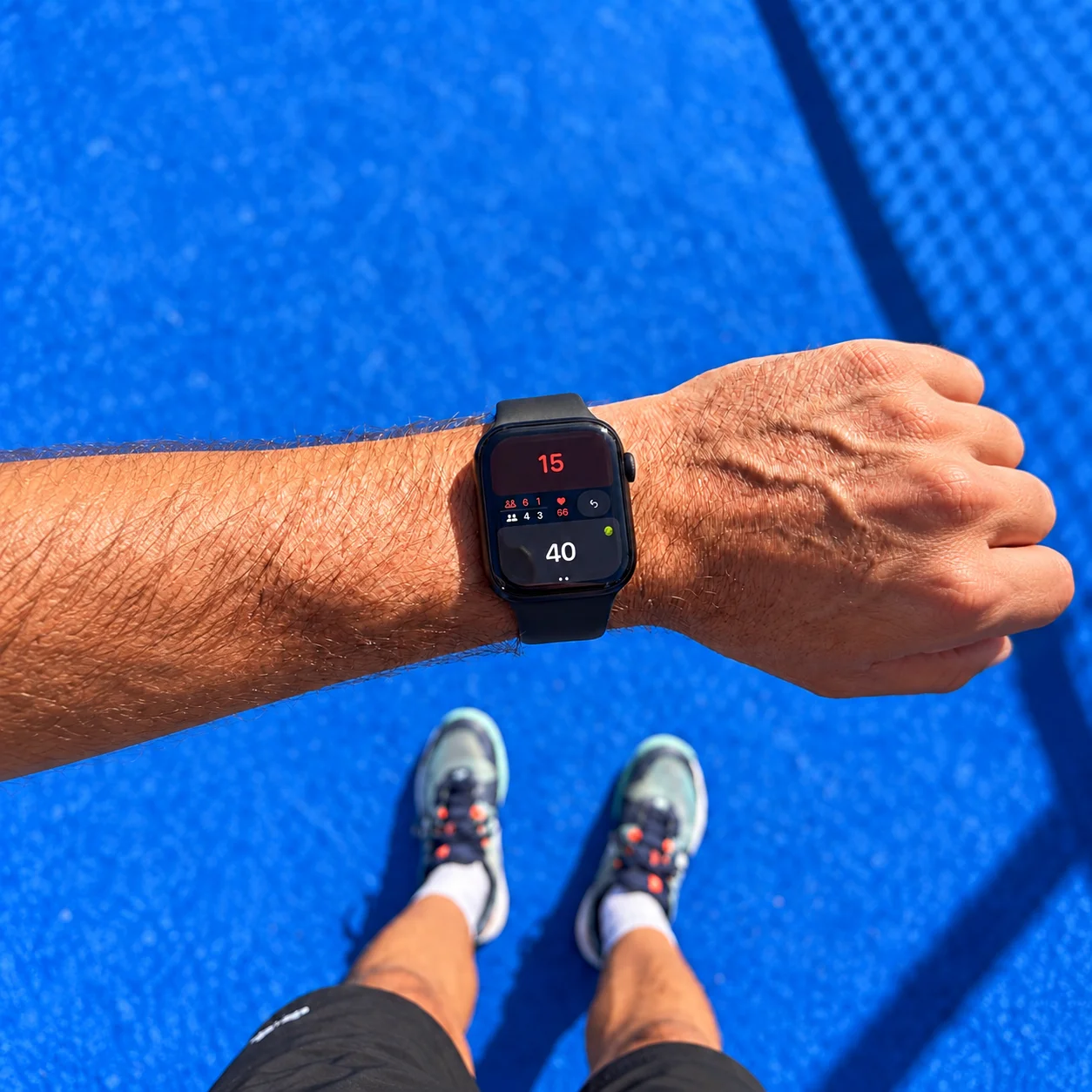 Padel Pointer showing a 15–40 score on a player’s wrist on a blue padel court
